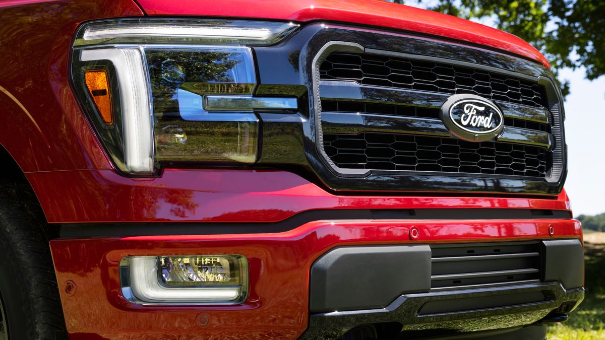 The front grill of a red, 2024 Ford F150 pickup.