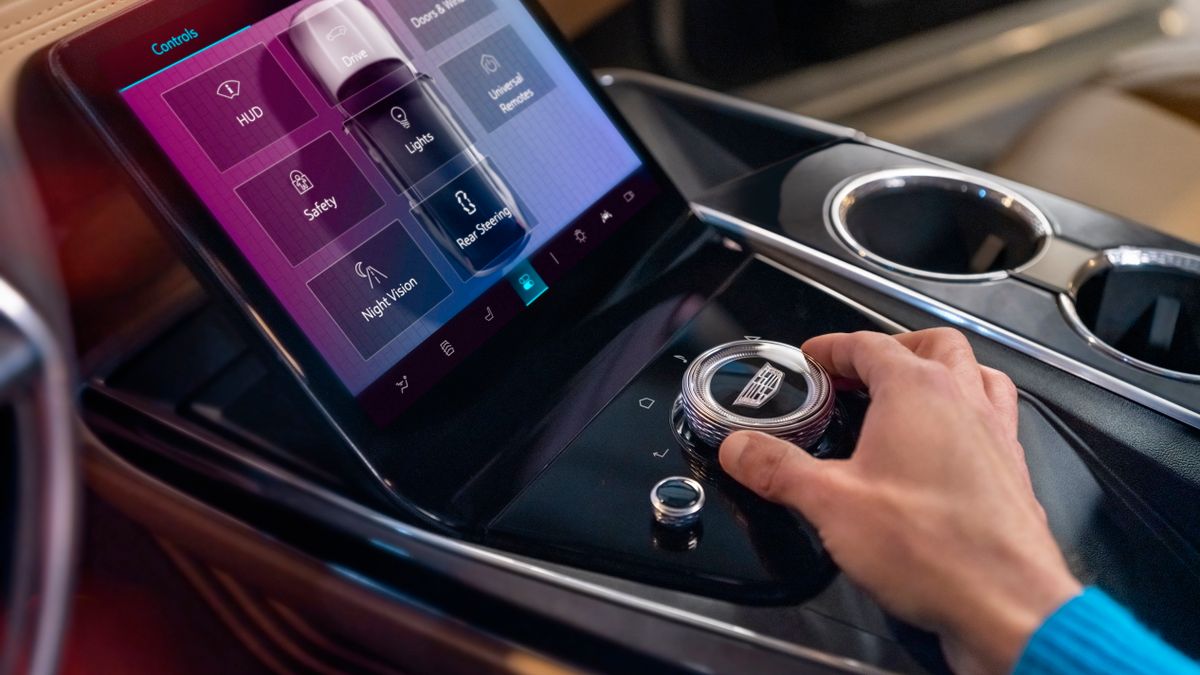 Close-up of man using the center control console in Cadillac Escalade SUV.