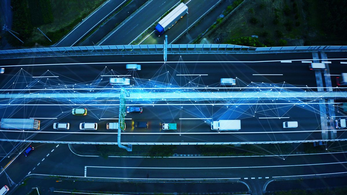 Overhead view of highway with cars and trucks with lines drawn among them implying connected vehicles using intelligent transportation systems.