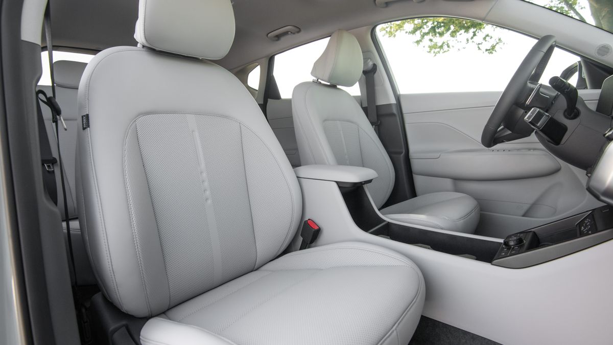 Light gray car seats and arm rest inside a car.