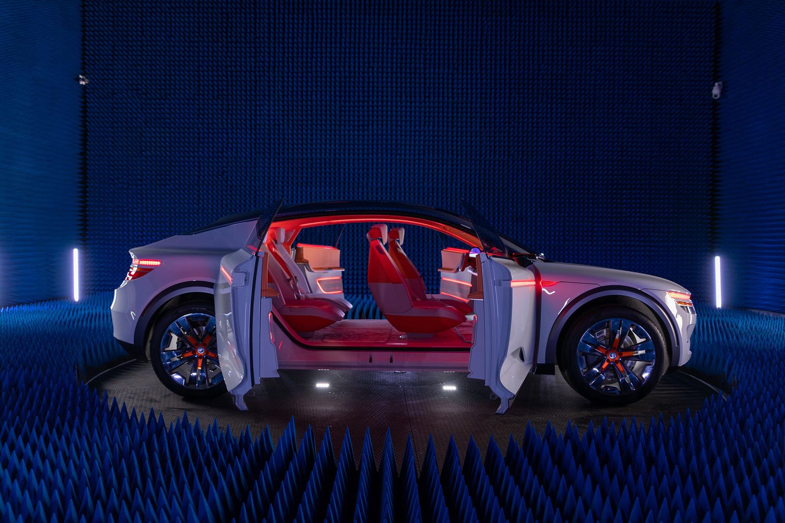 A white connected car with its doors open, revealing a red interior